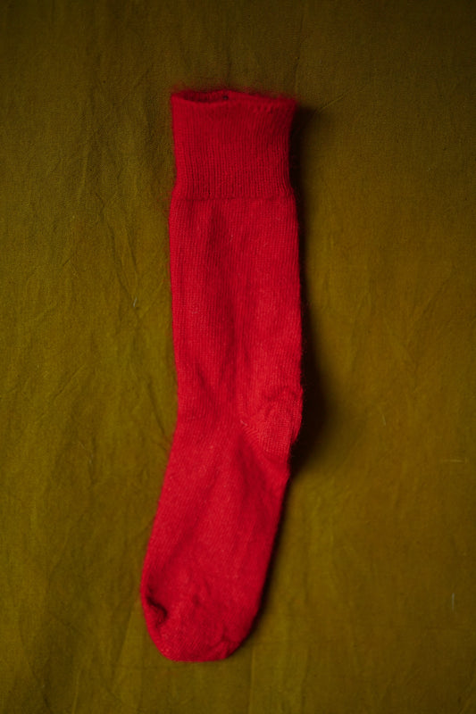Red mohair socks on green background